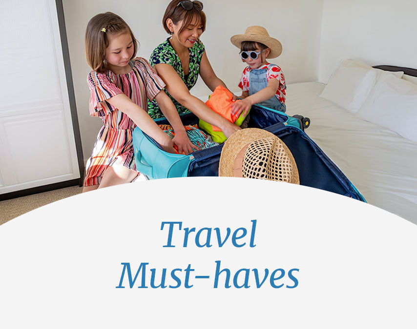 Mother and two daughters packing luggage in a room. Travel Must-haves.