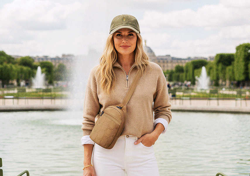 Gif of a woman in light clothes and purse standing in front of a huge water fountain. Couple standing on a hill, enjoying the sun with hats, scarf, backpack and a surf board. Men standing in front of an old district with green walls, with a medium crossbody bag.