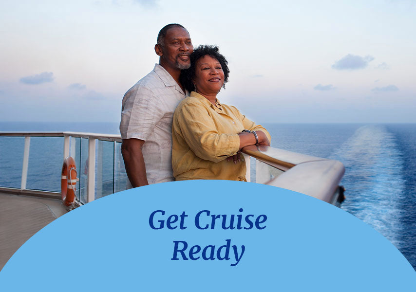 A couple standing on the back deck of a cruise ship, looking into the distance. Get Cruise Ready text is displayed on top on a blue oval shape on the foreground of the picture.