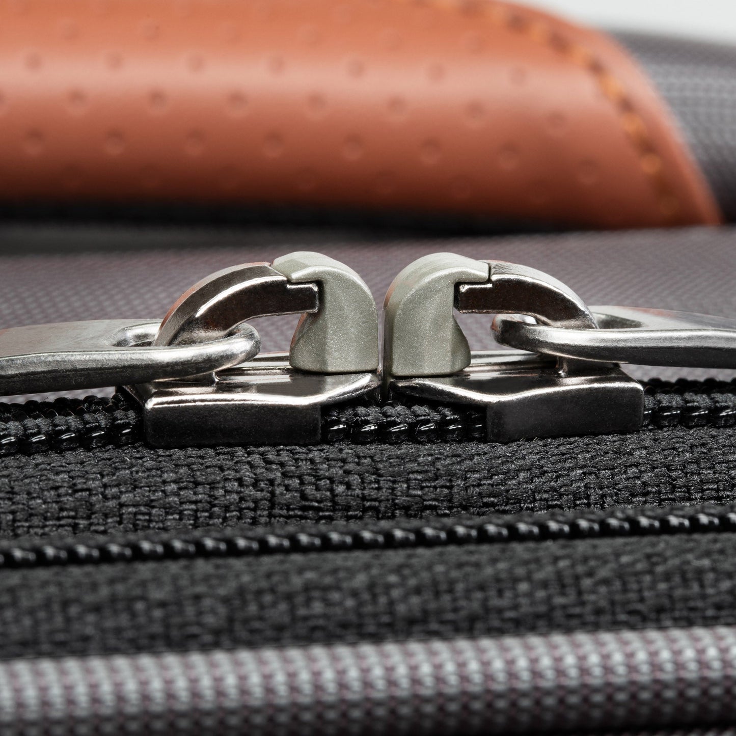 Close-up of two silver zipper pulls on the Ricardo Beverly Hills Montecito 3.0 Softside Medium Spinner.