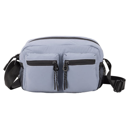 Bench Nylon Crossbody by Bench in light blue, features two zip pockets, mesh sides, and a black adjustable strap.