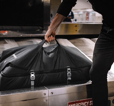 men lifting carry on bag from luggage pick up track