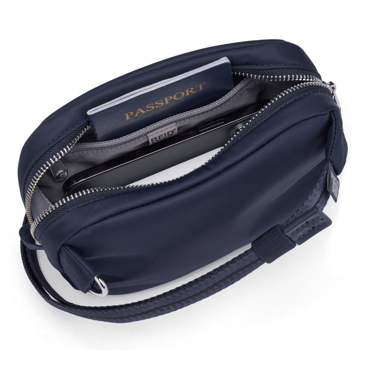 Top view of the Pacsafe® W Anti-theft Micro Sling by Pacsafe, with passport and phone in RFID blocking compartment.