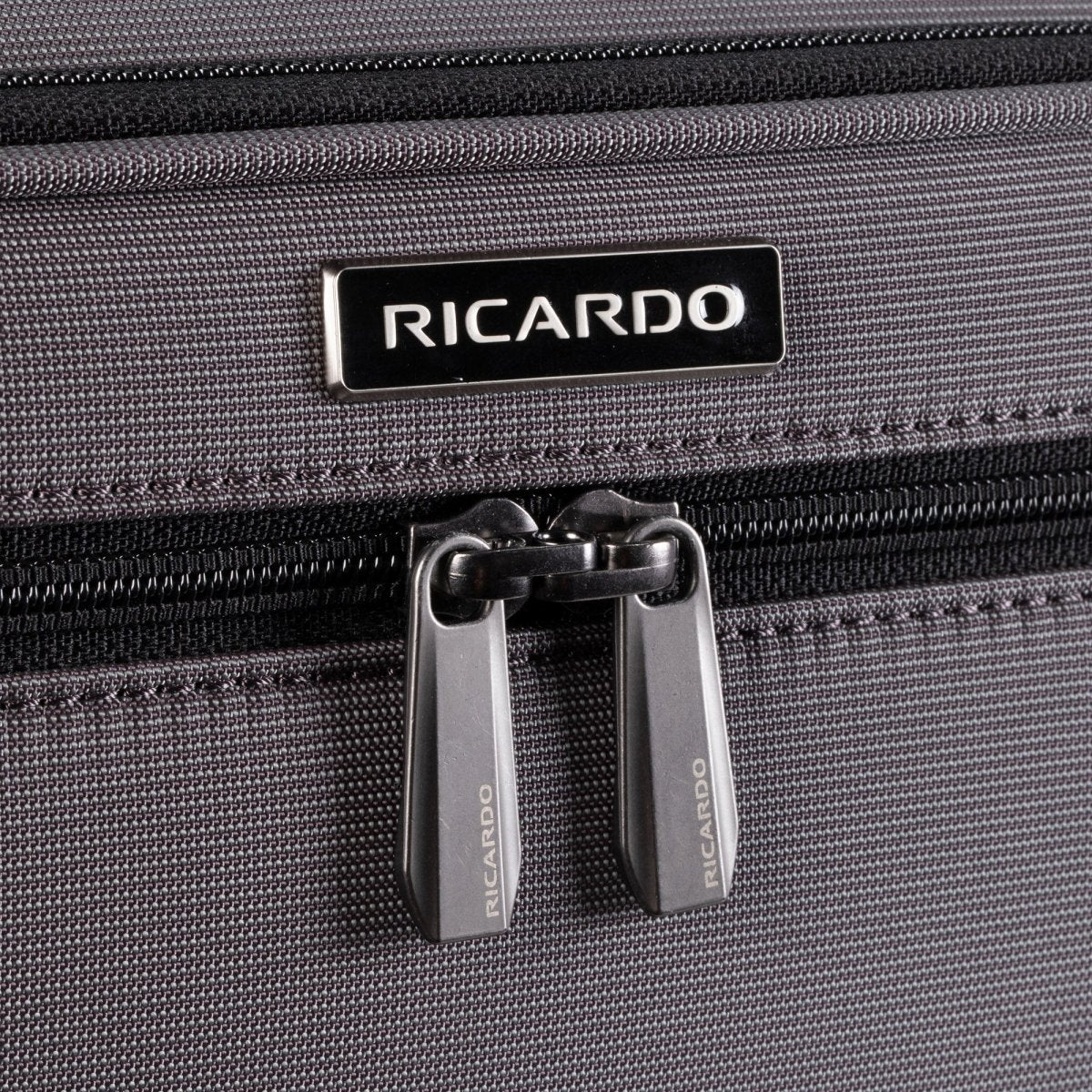 Close-up of Ricardo Beverly Hills Montecito 3.0 Softside Carry-on Spinner in gray with double zippers and logo above.