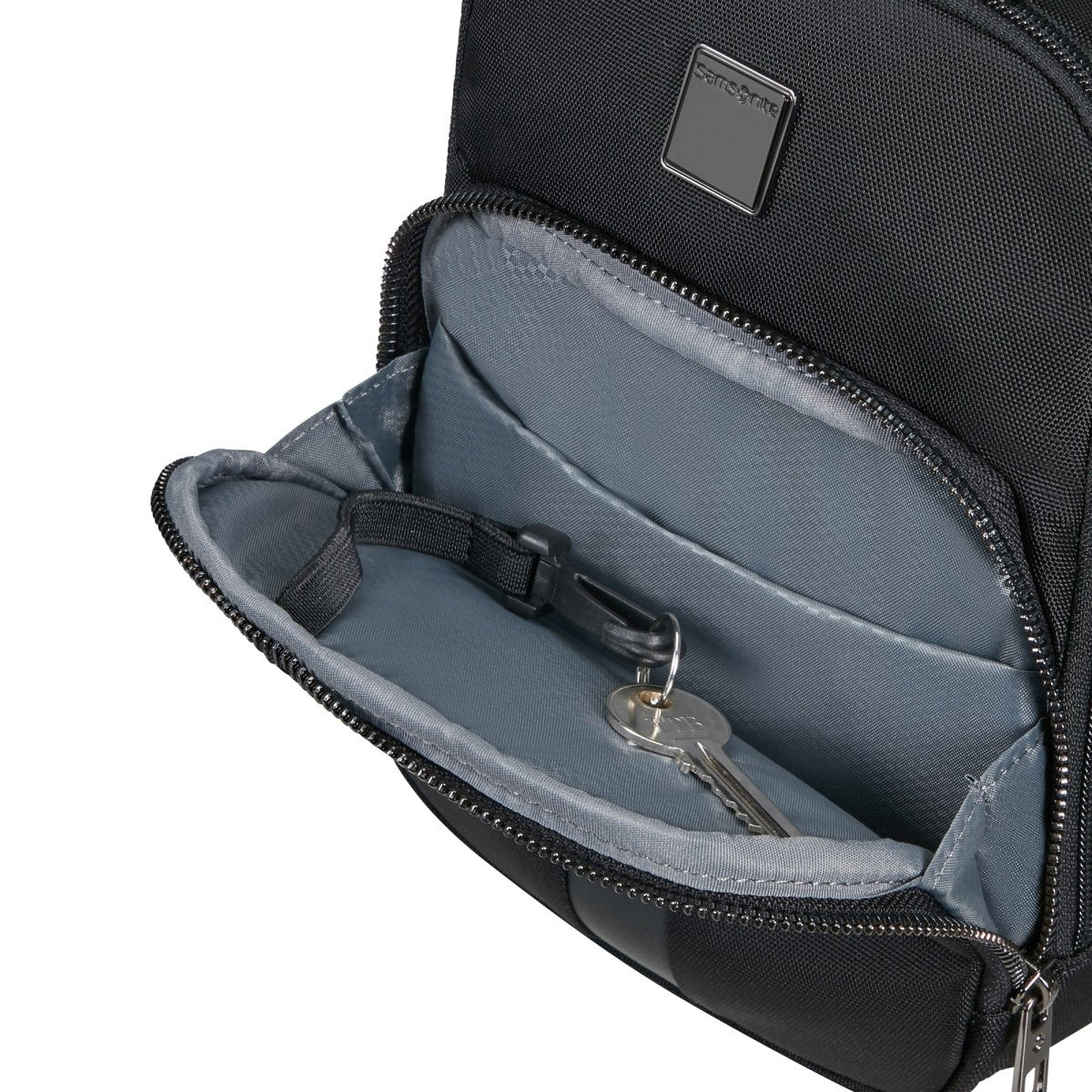 The stylish Samsonite SackSquare Crossbody Small in black, featuring an open front pocket for convenient hands-free mobility, includes a pair of keys secured to a clip inside.