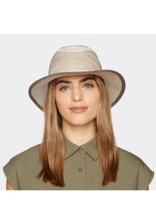 Product Image – A person wearing a Tilley TMH55 Mash-Up Airflo® in beige, accented with ventilation mesh, and a green collared shirt smiles slightly against a plain background, appreciating the comfort and style of sun protective fabric.