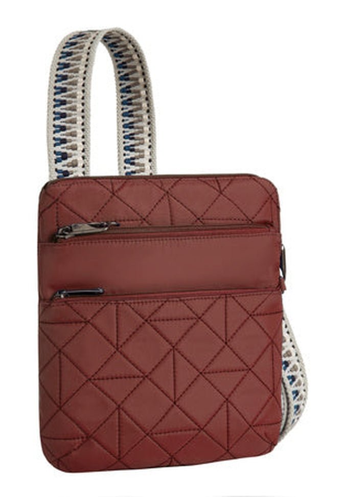 The Travelon Boho Anti-Theft Slim Crossbody, by Travelon, is a paprika quilted shoulder bag adorned with a geometric pattern. It comes with an RFID blocking organizer and two front zippers, and features a white strap accented with blue details, offering both style and security.