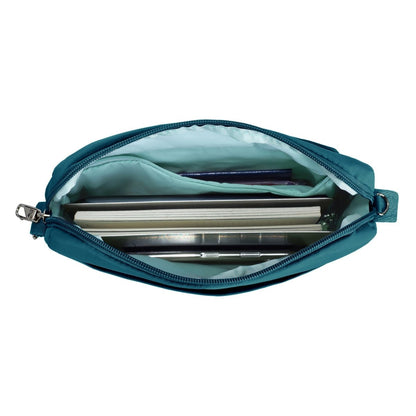 Open the capri blue Travelon Roam Anti-theft Crossbody showing notes, a pen, and an inner zippered pouch.