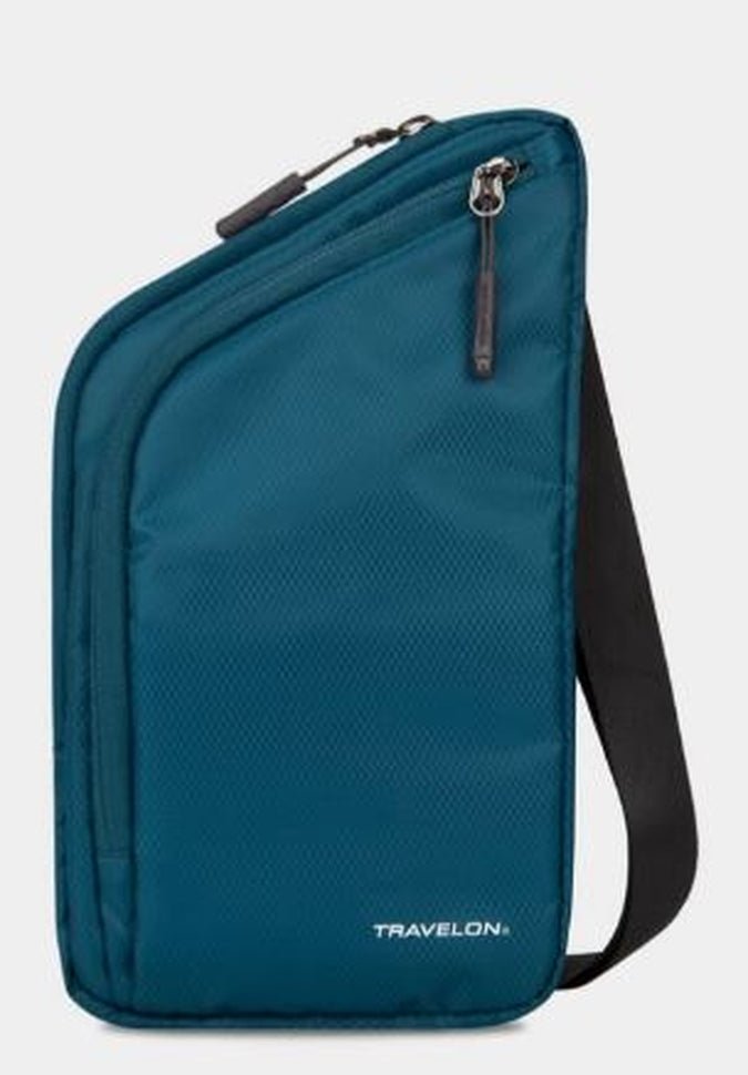 The Travelon World Travel Essentials Slim Crossbody Bag, essential for world travel, comes in a peacock teal color and features a zipper pocket with a black strap. This stylish crossbody bag is also RFID protected, ensuring your essentials are safe on the go.