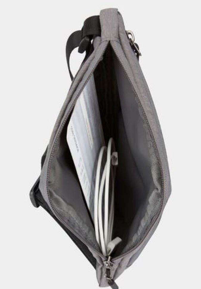 A gray Travelon World Travel Essentials Slim Crossbody Bag with a book and white cables inside, viewed from above—an ideal choice for your travel essentials.