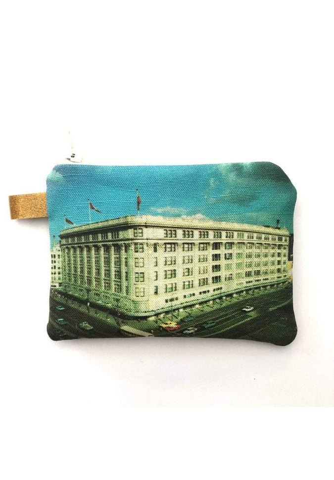 The Winnipeg North of Fargo Coin Purse beautifully features a vintage-style print of a majestic building adorned with columns and flags set against a blue sky, complemented by an interlined design for enhanced durability.