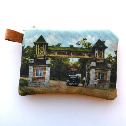 The Winnipeg North of Fargo Coin Purses boast a vintage-style design with an interlined interior, showcasing an image of a national park entrance with two towers and an old car, making them ideal for storing earbuds or small items.