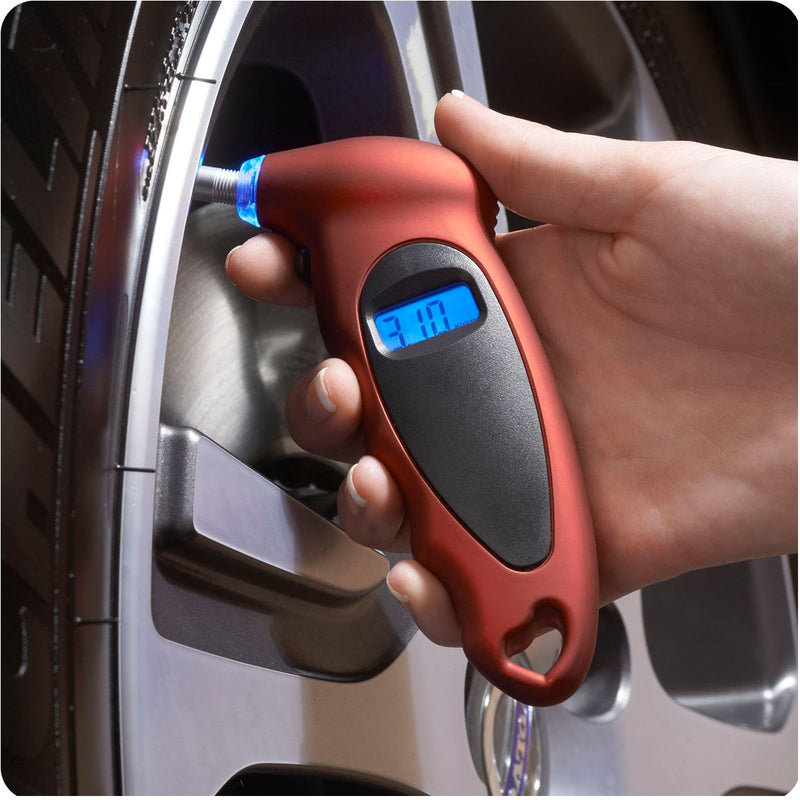 Image showing a hand holding the product in red colour and testing the pressure on a tire.
