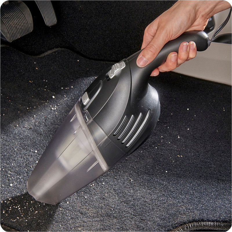 Image showing hand using vacuum on a vehicle floor.